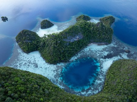 Kalksteininseln erheben sich aus der tropischen Meereslandschaft von Raja Ampat. Diese Region Indonesiens ist aufgrund der außerordentlichen Artenvielfalt im Meer als das Herz des Korallendreiecks bekannt..