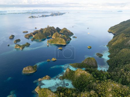 Beautiful limestone islands rise from Raja Ampat's tropical seascape. This region of Indonesia is known as the heart of the Coral Triangle due to the extraordinary marine biodiversity found there.