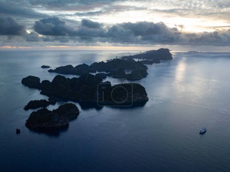 Die von Riffen gesäumten Kalksteininseln erheben sich aus der tropischen Meereslandschaft von Raja Ampat. Diese Region Indonesiens ist aufgrund der hohen Artenvielfalt im Meer als das Herz des Korallendreiecks bekannt..