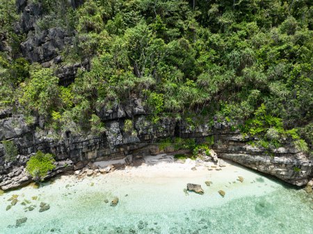 A secluded beach is found on a remote island in Raja Ampat's tropical seascape. This region of Indonesia is known as the heart of the Coral Triangle due to the high marine biodiversity found there.