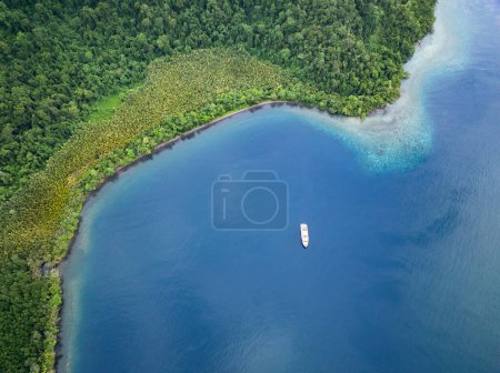 Ein Tauchkreuzfahrtschiff liegt vor Anker entlang der Küste der südlichen Batanta, Raja Ampat. Diese Region ist aufgrund der hohen Artenvielfalt im Meer als das Herz des Korallendreiecks bekannt..