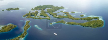 Die malerischen Kalksteininseln von Pef, gesäumt von Riffen, erheben sich aus der tropischen Meereslandschaft von Raja Ampat. Dieser Teil Indonesiens ist aufgrund seiner hohen Artenvielfalt im Meer als das Herz des Korallendreiecks bekannt.