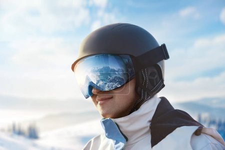 Photo for Close Up Of The Ski Goggles Of A Man With The Reflection Of Snowed Mountains. Snowboarder Man on The Background Blue Sky.  Winter Sports - Royalty Free Image