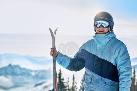 Photo for Portrait of a skier in the ski resort on the background of mountains and blue sky, Bukovel.  Ski goggles of a man wearing ski glasses. Winter Sports - Royalty Free Image