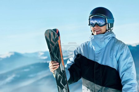 Photo for Portrait of a skier in the ski resort on the background of mountains and blue sky, Bukovel.  Ski goggles of a man wearing ski glasses. Winter Sports - Royalty Free Image