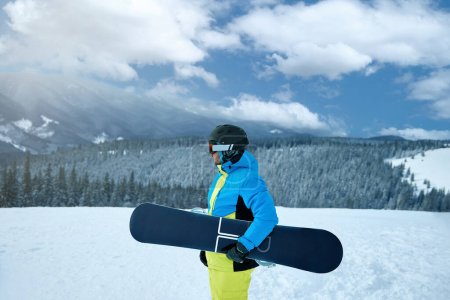 Photo for Portrait of man at  ski resort on the background mountains holds snowboard. Wearing ski glasses - Royalty Free Image