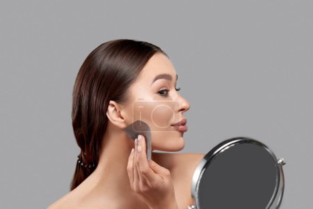 Téléchargez les photos : Beautiful woman using facial oil blotting paper.  Beauty concept. Cosmetology, cosmetics. Facial treatment - en image libre de droit