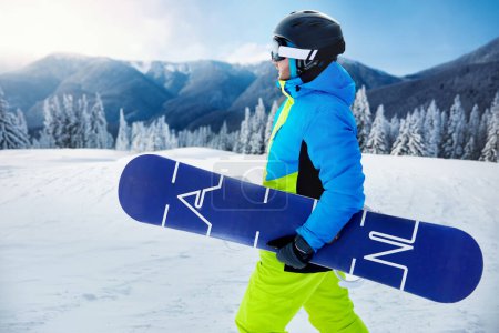 Photo for Snowboarder with action camera on a helmet. Close up Portrait of snowboarder in Carpathian Mountains, Bukovel Snowboarder. A mountain range reflected in the ski mask. - Royalty Free Image