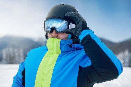 Photo for Close Up Of The Ski Goggles Of A Man With The Reflection Of Snowed Mountains. Man In The Background Blue Sky.  Winter Sports. - Royalty Free Image