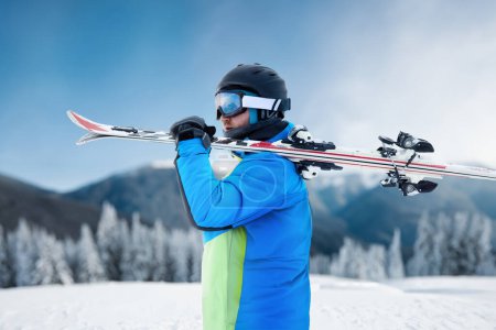 Photo for Portrait of a skier in the ski resort on the background of mountains and blue sky, Bukovel. Ski goggles of a man wearing ski glasses. Winter Sports - Royalty Free Image