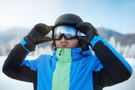 Photo for Close up of the ski goggles of a man with the reflection of snowed mountains. A mountain range reflected in the ski mask. Portrait of man at the ski resort on the background of mountains and sky - Royalty Free Image
