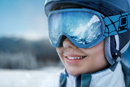 Photo for A Mountain Range Reflected In The Ski Mask. Winter Sports. Woman At The Ski Resort On The Background Of Mountains And Blue Sky. - Royalty Free Image