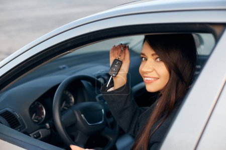 Téléchargez les photos : Conducteur de voiture femme souriant montrant de nouvelles clés de voiture
. - en image libre de droit