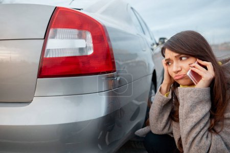 Foto de Mujer de pie cerca de auto rayado. pedir ayuda. seguro de coche. - Imagen libre de derechos