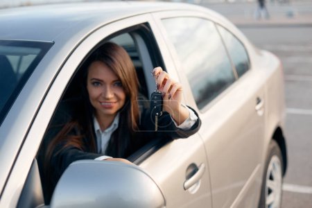 Téléchargez les photos : Souriante jeune femme d'affaires tenant des clés de voiture. Concept d'achat de voiture. - en image libre de droit