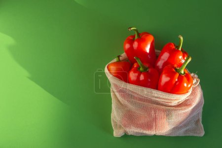 Foto de Pimientos dulces rojos en una bolsa de compras sobre un fondo verde. espacio de copia - Imagen libre de derechos