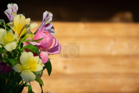 Téléchargez les photos : Bouquet de fleurs contre mur en bois flou. Fond horizontal pour bannières, félicitations, présentations. - en image libre de droit