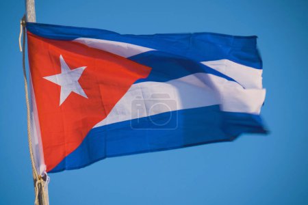 Cuban flag flying in the wind on a backdrop of blue sky. National symbol. Close-up view of the Cuba national flag waving in the wind.