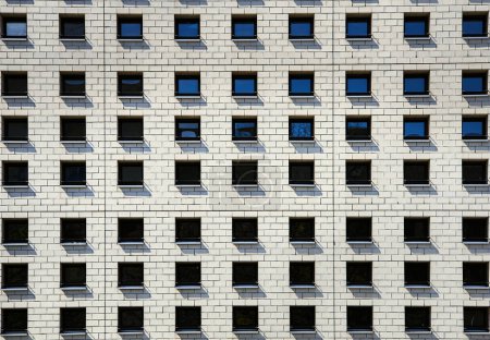 Compartir alojamiento en un espacio abarrotado muestra una cohabitación moderna y difícil o la convivencia en las capitales con el patrón de pequeñas ventanas adyacentes en la fachada moderna. Cuestión de espacio vital en una gran ciudad - Berlín, Alemania