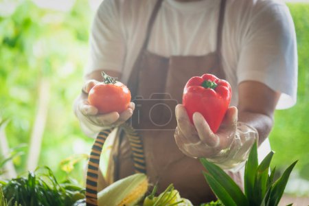 Photo for Farmer standing in the farm and selecting vegetables for sale. Selective focus - Royalty Free Image