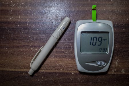 Foto de Un glucómetro y una pluma lanceta, prueba de glucosa en sangre, medición del nivel de glucosa análisis de sangre. - Imagen libre de derechos