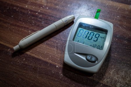 Foto de Un glucómetro y una pluma lanceta, prueba de glucosa en sangre, medición del nivel de glucosa análisis de sangre. - Imagen libre de derechos