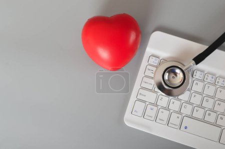 Foto de Estetoscopio, corazón rojo y teclado del ordenador. Concepto de consulta médica en línea. - Imagen libre de derechos