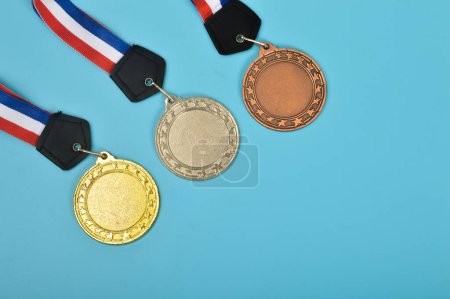 Téléchargez les photos : Le trophée de la première place est complété par un ensemble de médailles qui comprend l'or, l'argent et le bronze, ainsi que des prix de champion et gagnant avec une lanière - en image libre de droit