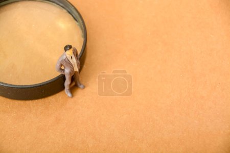 Foto de Un curioso hombre de negocios de pie, usando una lupa para explorar nuevas oportunidades en el mercado - Imagen libre de derechos