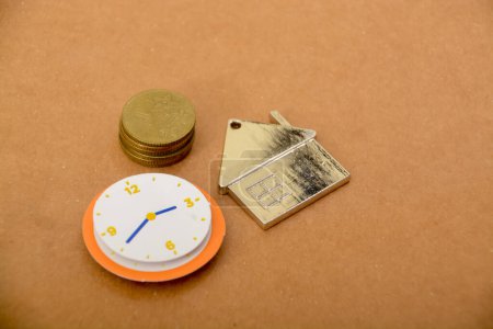 Photo for A clock, money and house. constant reminder that saving money for a home that requires patience and timely financial planning. - Royalty Free Image