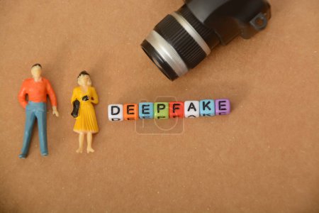 Téléchargez les photos : Personnes miniatures et appareil photo avec texte DEEPFAKE.A deepfake est un type de média synthétique qui implique l'utilisation de l'intelligence artificielle - en image libre de droit