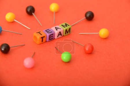 Alphabet beads with text TEAM. In a business context, a team refers to a group of individuals working collaboratively and cooperatively toward a common goal or objective.