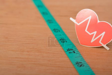 Photo for Heartbeat rate symbol and measuring tape. keeping track of your heart rate provides you with real-time data so you can adjust your output to suit your fitness goals - Royalty Free Image