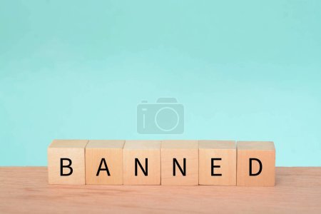 Photo for Wooden block with text BANNED. A ban refers to a formal or official prohibition or restriction on a particular activity, action, item, or person. It is an authoritative decision made by a government - Royalty Free Image