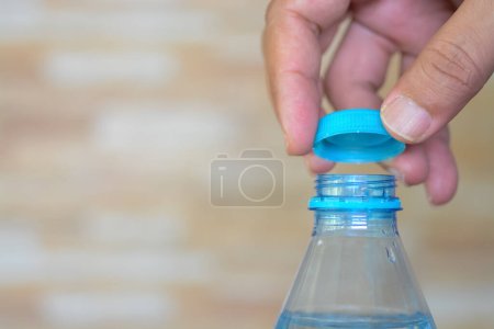 Hände drehen zart den Verschluss einer erfrischenden Wasserflasche auf, bereit, den Durst zu löschen.