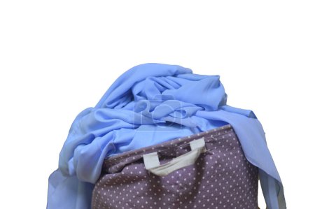Der überquellende Wäschekorb voller Hemden wartet in der Waschmaschine darauf, an der Reihe zu sein, ein Beleg für den geschäftigen Rhythmus des täglichen Lebens.