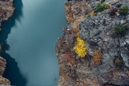Foto de Vista aérea vertical de la superficie del tranquilo río de montaña turquesa entre las orillas rocosas. - Imagen libre de derechos