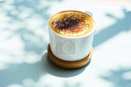 Foto de Vista lateral de café en polvo en la mesa azul con hermosas sombras. ambiente acogedor cafetería. Humor de verano - Imagen libre de derechos