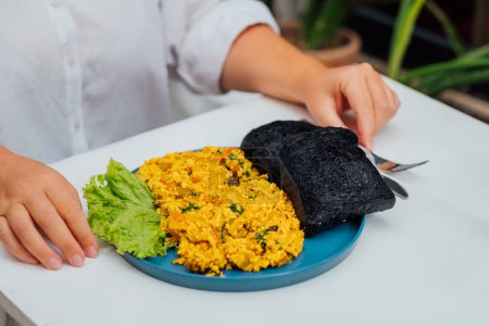 Placa de huevos revueltos de tofu emparejados con pan de carbón, desayuno vegano moderno.