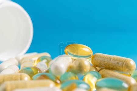 Photo for Various multicolor capsules, herbal vitamin pills or drugs for treatment on blue background, medicine and healthcare concept, close-up view. - Royalty Free Image