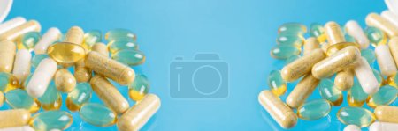 Various multicolor capsules, herbal vitamin pills or drugs for treatment on blue background, medicine and healthcare concept, close-up view.