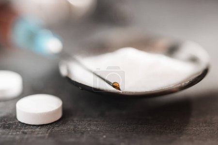 Photo for Drop of narcotic substances on a syringe needle, white pills and drugs powder, extreme close-up view. Concept of addiction and bad habits. - Royalty Free Image