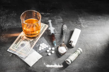 Photo for Alcohol drink in a glass, syringe with a dose of drugs, white pills in a transparent bag, narcotics powder in a spoon and US dollar cash on dark background. Concept of addiction and bad habits. - Royalty Free Image