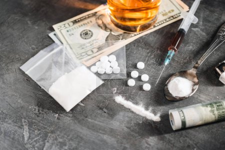 Photo for White pills, alcohol drink in a glass, syringe with a dose of drugs, narcotics powder and US dollar cash on dark background. Concept of addiction and bad habits. - Royalty Free Image