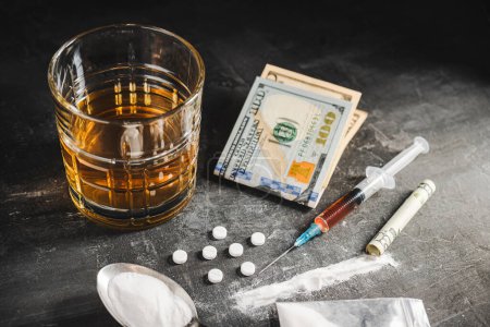 Photo for Alcohol drink in a glass, syringe with a dose of drugs, white pills, narcotics powder in a transparent bag and US dollar currency cash on a dark background. Concept of addiction, abuse and bad habits. - Royalty Free Image