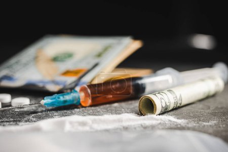 Photo for Syringe with a dose of drugs, white pills, powder narcotics, and US dollar currency on dark background. Concept of addiction, abuse and bad habits. - Royalty Free Image