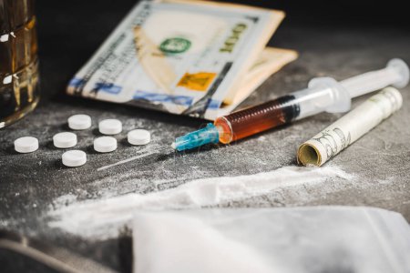 Photo for Syringe with a dose of drugs, white pills, powder narcotics, and US dollar currency on dark background. Concept of addiction, abuse and bad habits. - Royalty Free Image