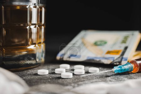 Photo for Drugs white pill, syringe with a dose of narcotic substances, white powder cocaine, alcohol drink in a glass and US dollar currency on dark background. Concept of addiction, abuse and bad habits. - Royalty Free Image