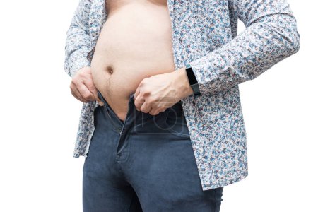 Téléchargez les photos : Homme en surpoids avec gros ventre essayant de fixer un pantalon serré, isolé sur fond blanc. - en image libre de droit