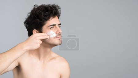 Photo for A young caucasian man with stubble beard is making a face mask - Royalty Free Image